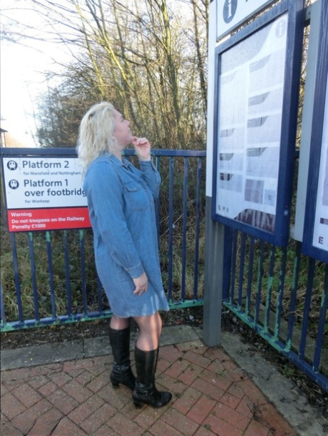 Older blonde Barby exposes her tits and pussy on a train station platform