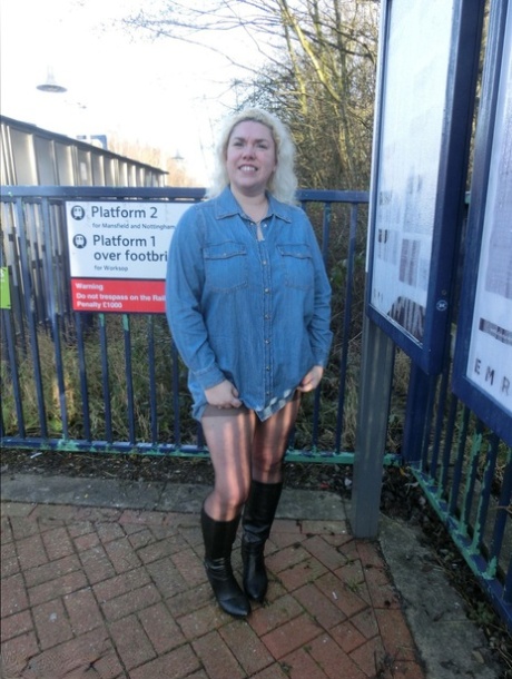 Older blonde Barby exposes her tits and pussy on a train station platform