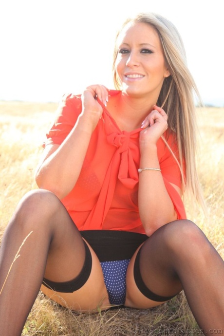 Blonde hottie Candice exposes her curves and natural tits in a meadow